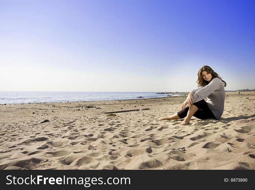 The image of a beautiful brunette girl on the beach