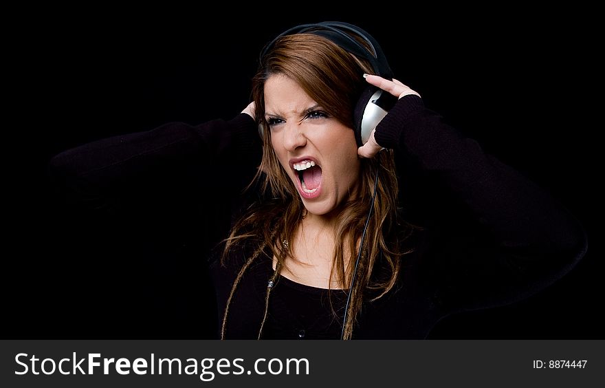 Portrait of shouting young woman listening music