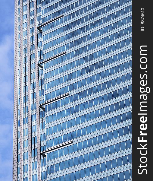 A fragment of city skyscraper, photo was taken in Warsaw. the buliding window's are reflecting blue sky. A fragment of city skyscraper, photo was taken in Warsaw. the buliding window's are reflecting blue sky