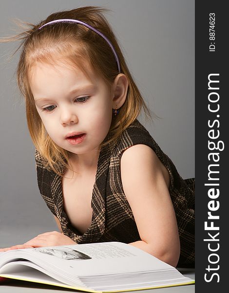 Girl lying and reading book.