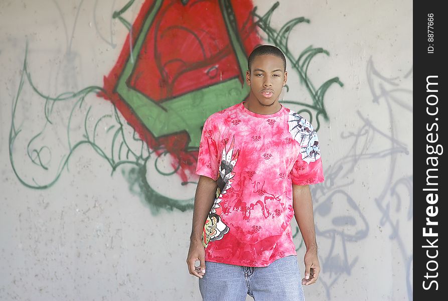 One young African American guy outdoor portrait with graffiti. One young African American guy outdoor portrait with graffiti