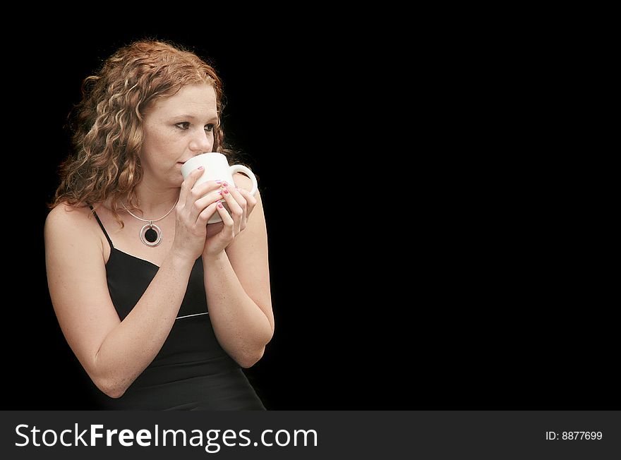 Attractive redhead in a black dress drinking coffee with copyspace. Attractive redhead in a black dress drinking coffee with copyspace