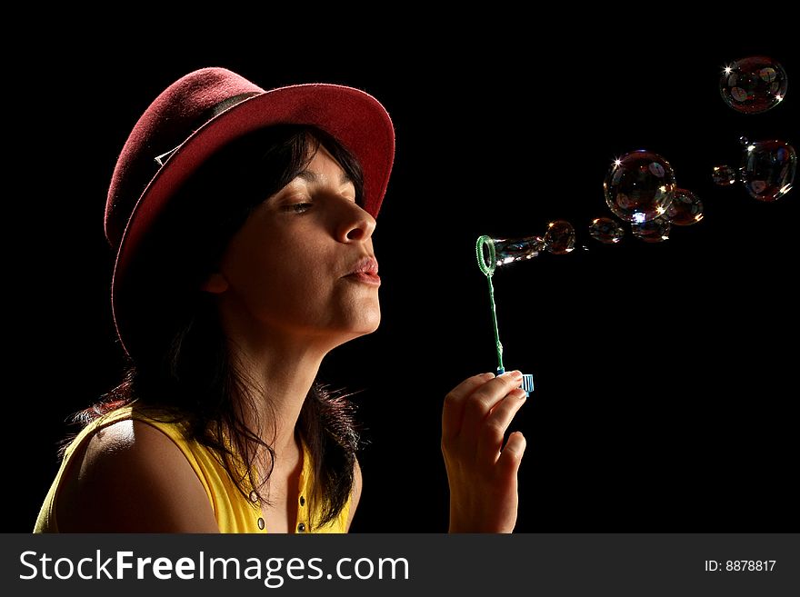 Young brunette girl and bubbles, isolated on black