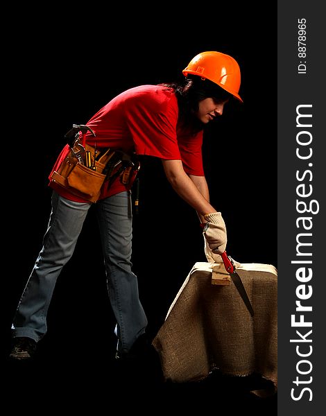 Young woman with work tools and hand saw, isolated on black