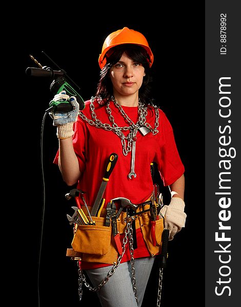Young woman with work tools and drill, isolated on black