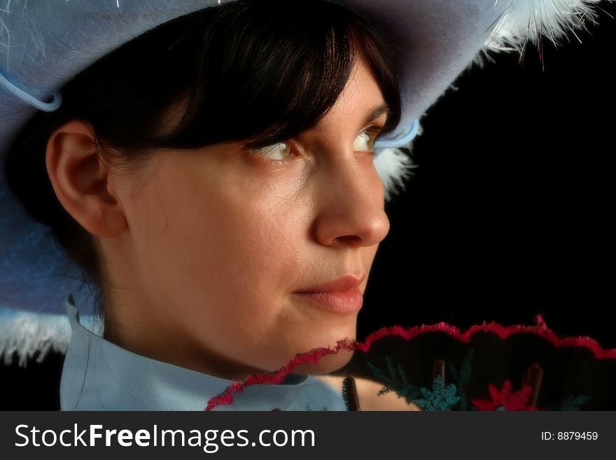 Brunette girl with cowboy hat and spanish fan