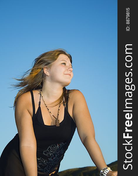 Beautiful young woman enjoying sunshine and breeze