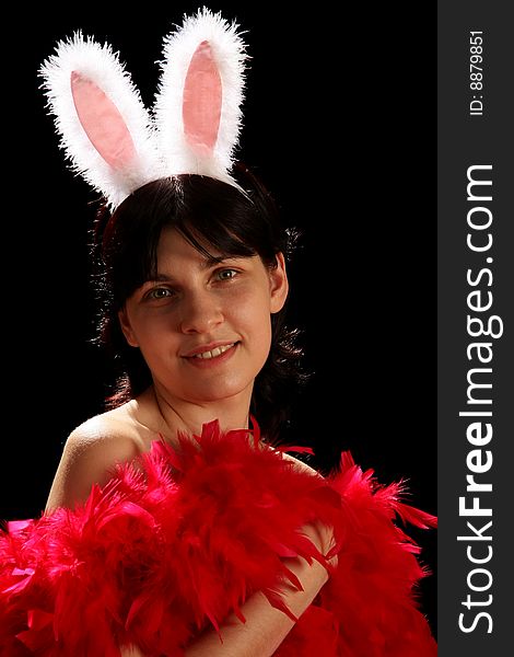 Young woman with fun bunny ears and red feathers, isolated on black