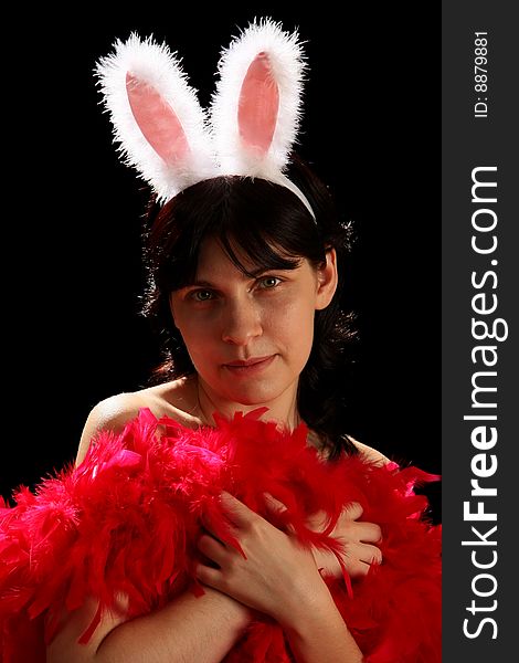 Young woman with fun bunny ears and red feathers, isolated on black