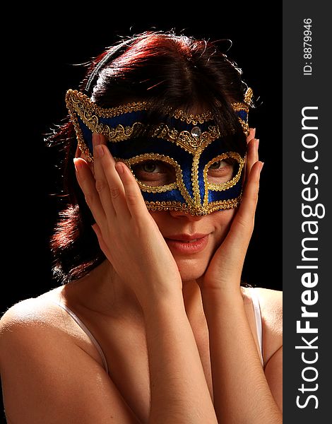 Young brunette with venetian mask, isolated on black