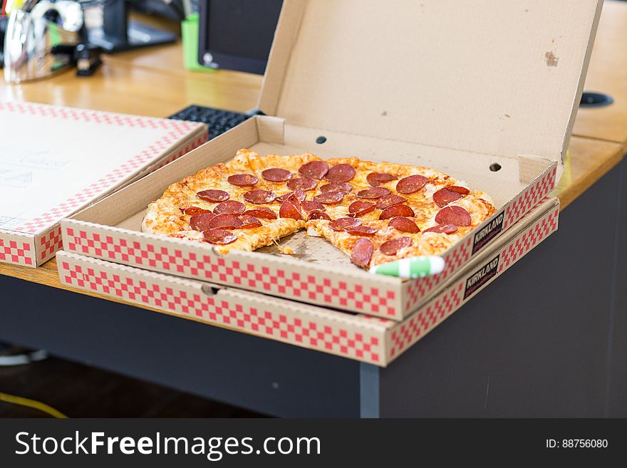 A pizza box with salami or pepperoni pizza on the table. A pizza box with salami or pepperoni pizza on the table.