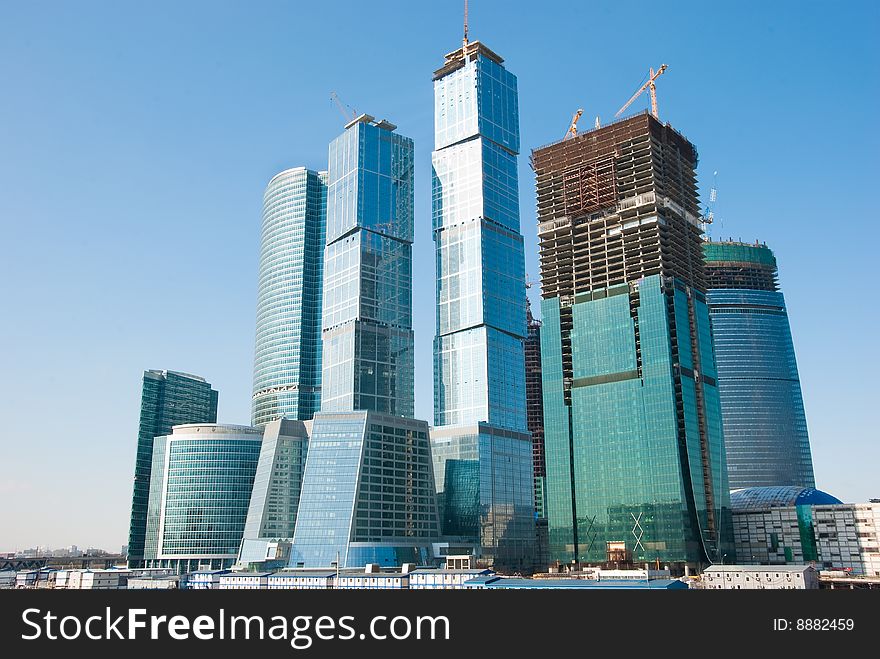 Sky-scrapers construction in Moscow, Russia Cranes and buildings over blue sky.