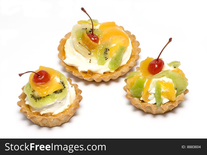 Cupcakes with cream and fruits on white background