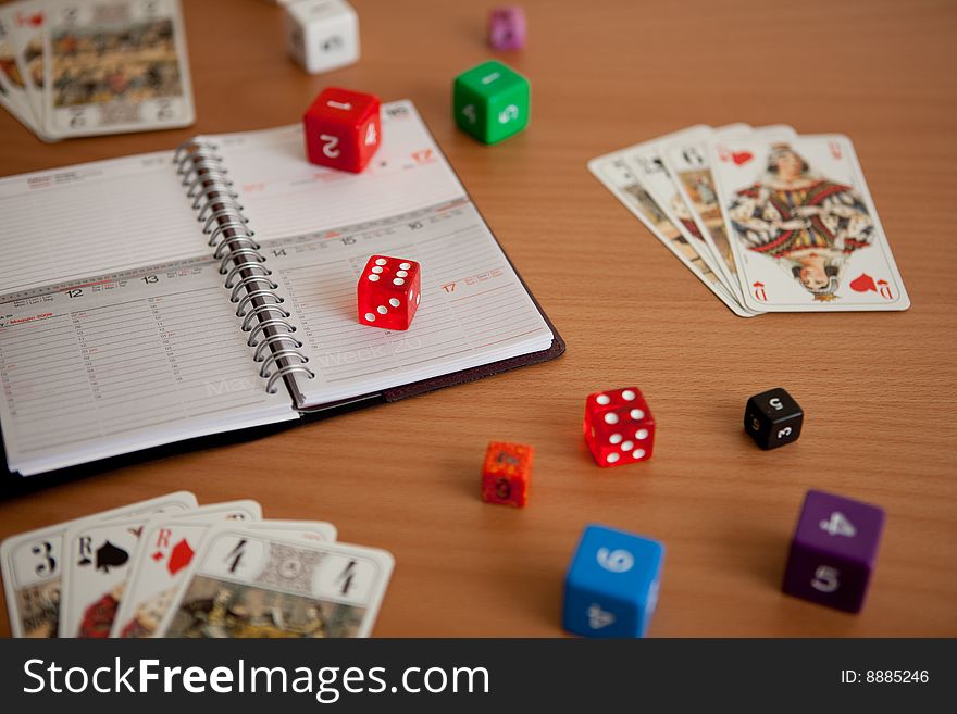 Agenda with dices and tarots on a brown table