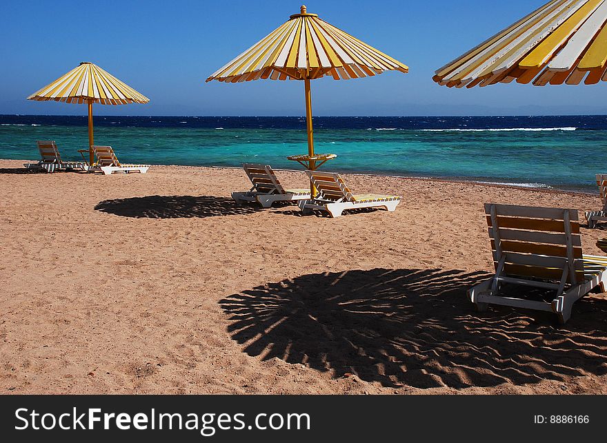 Resort in Dahab, Egypt. Umbrellas and chaise lounges. Resort in Dahab, Egypt. Umbrellas and chaise lounges