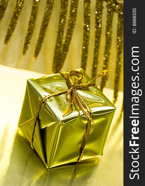 Gift box on golden background with leaf