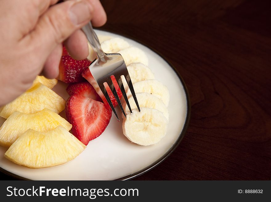 Picking up a slice of fresh banana on a fork. Picking up a slice of fresh banana on a fork