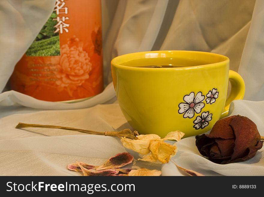 Still-life with yellow cup of green tea