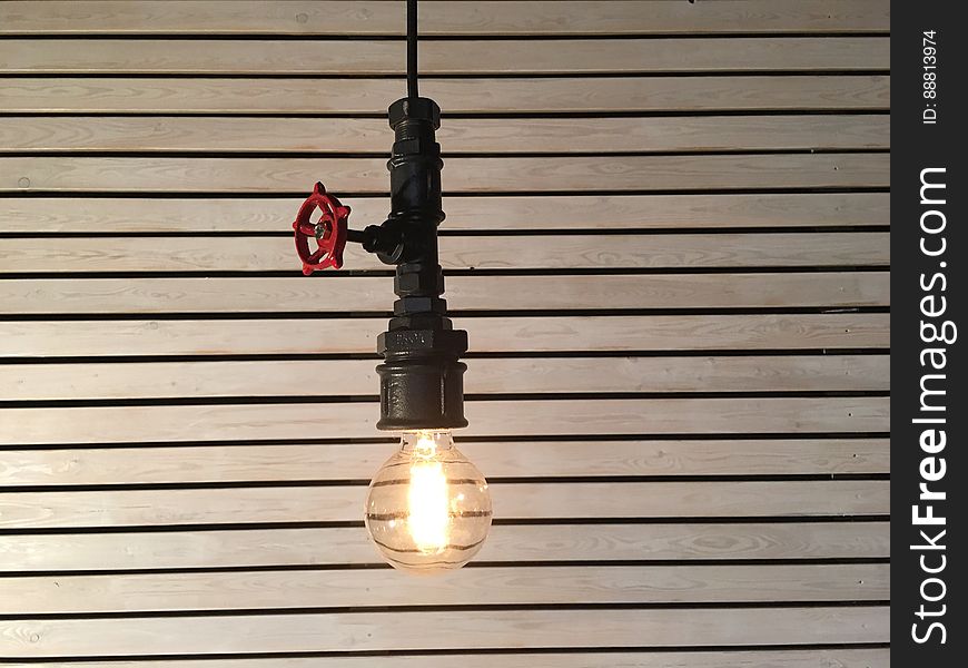 A close up of a hanging light bulb with a valve. A close up of a hanging light bulb with a valve.