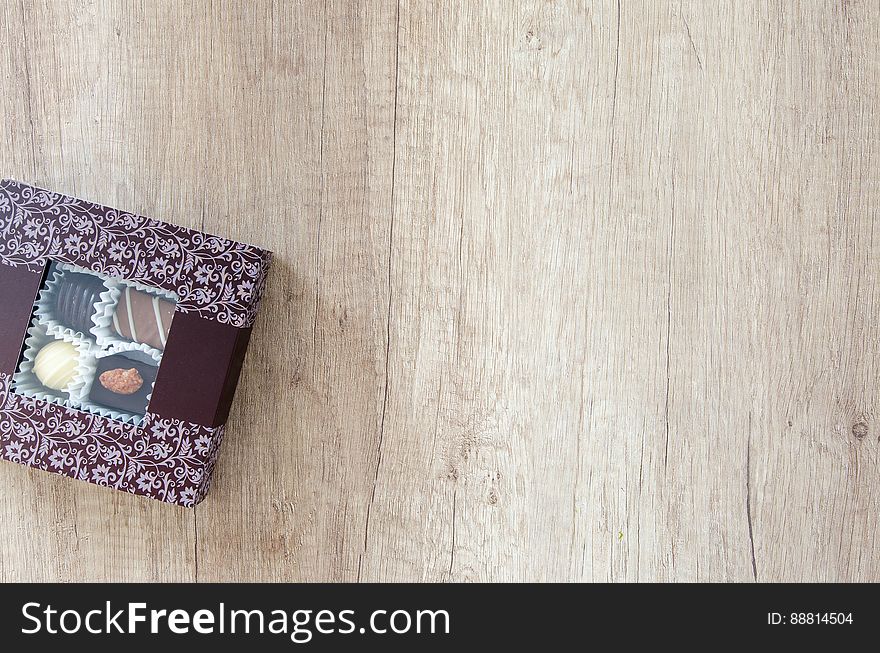 A box of chocolates on wood background.