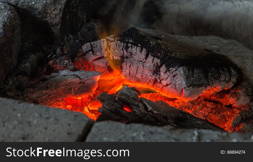 A fireplace with burning coals and cinders.