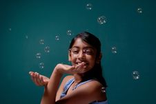 Girl Playing With Surrounded Bubbles Stock Images