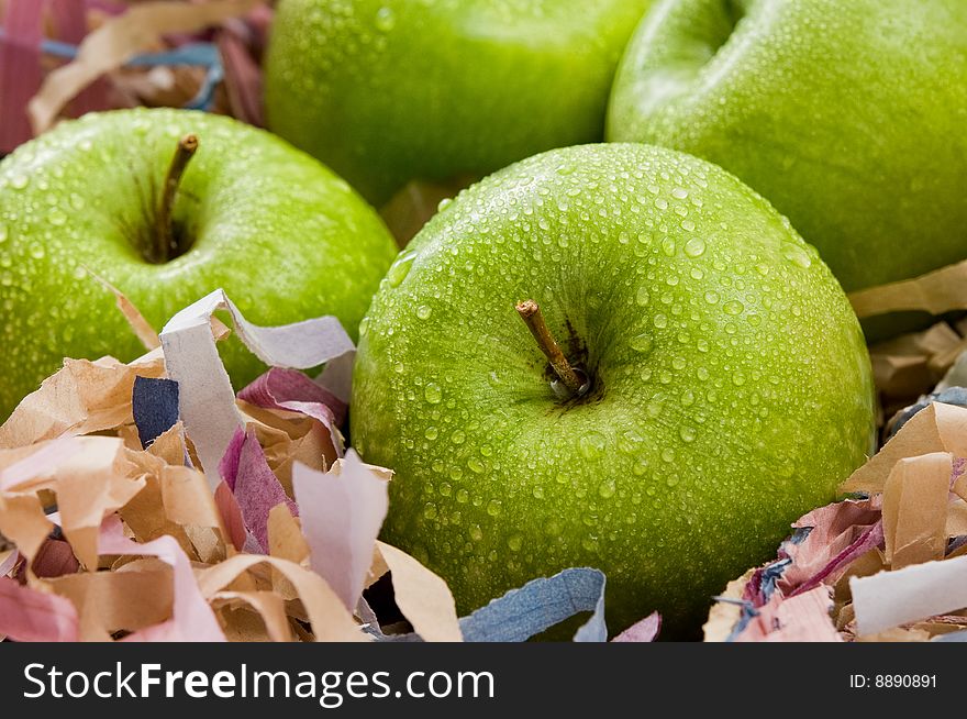 Green apples in a box with paper strips