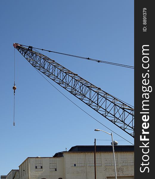 A tall construction crane in an urban city. A tall construction crane in an urban city