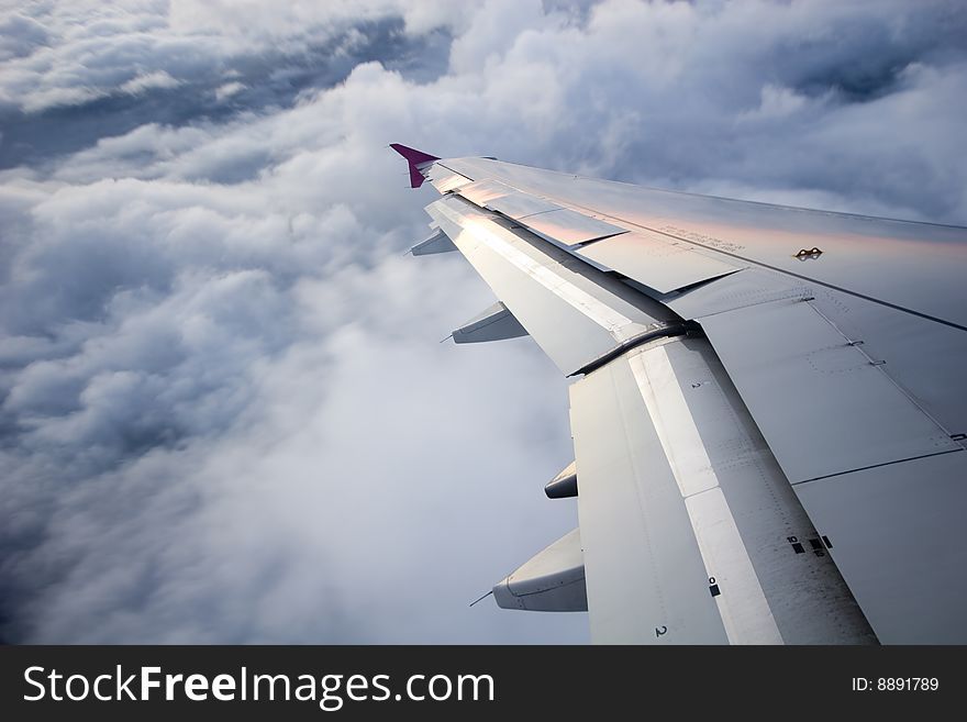 Sunrise over the clouds, high in the sky, view from the plane, with close up on the wing. Sunrise over the clouds, high in the sky, view from the plane, with close up on the wing