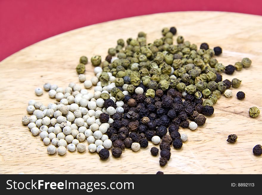 Mixed Pepper Grains On The Cutting Board With Mort