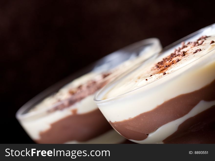 Chocolate and vanilla pudding in a parfait glass dusting of chocolate on top. Chocolate and vanilla pudding in a parfait glass dusting of chocolate on top