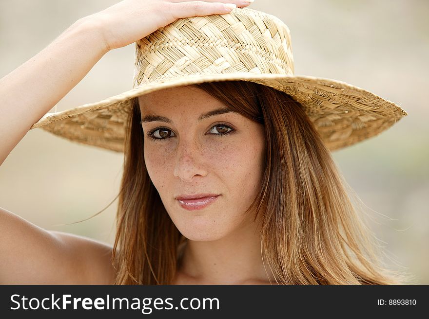 Portrait of a young brunette with a straw hat. Portrait of a young brunette with a straw hat