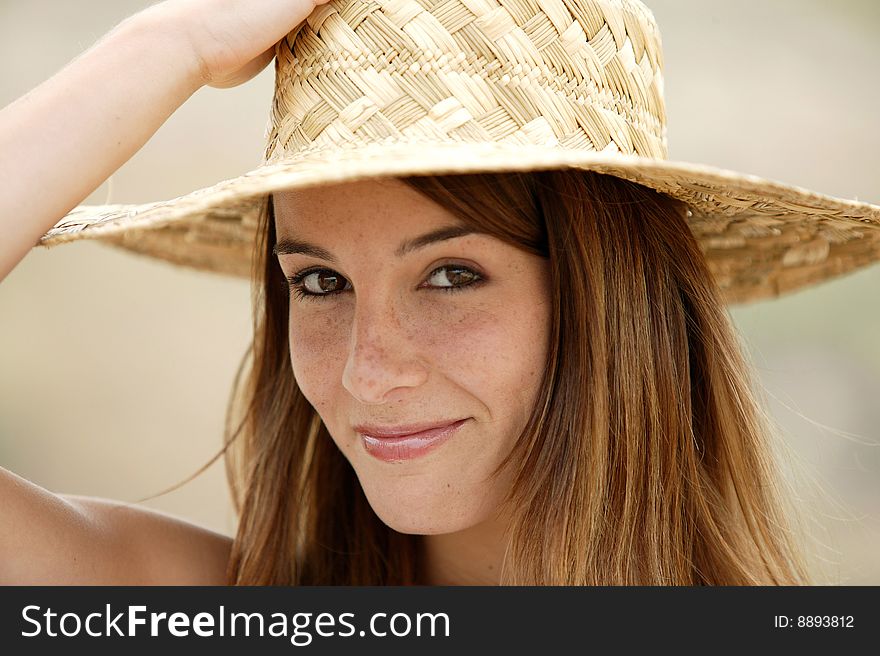 Portrait of a young brunette with a straw hat. Portrait of a young brunette with a straw hat