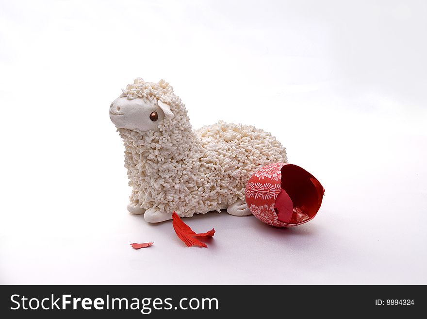 Isolated, artificial Easter Lamb and cracked, hollow, red Ester Egg, handmade with pattern. White background. Isolated, artificial Easter Lamb and cracked, hollow, red Ester Egg, handmade with pattern. White background