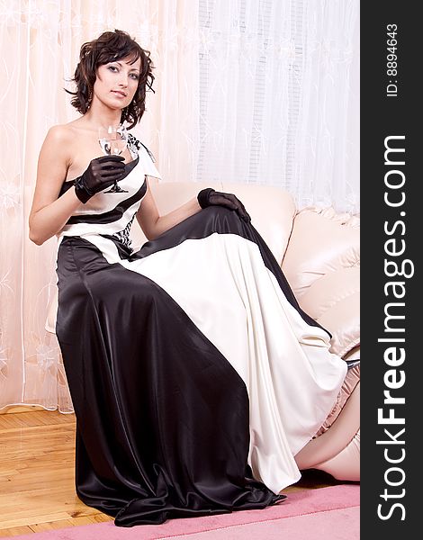 Woman in black and white dress posing in an armchair