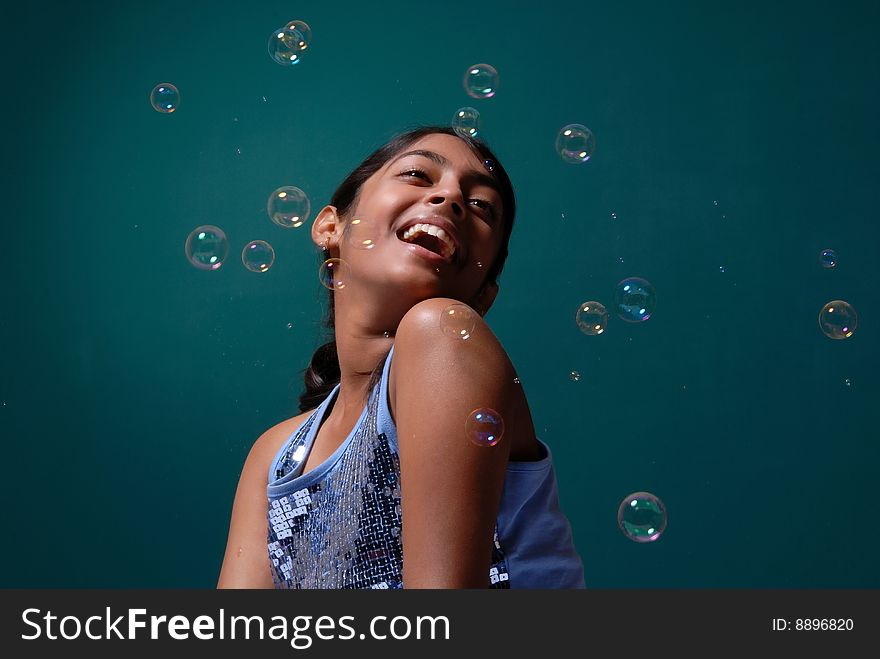 Charming girl surrounded by soap bubbles