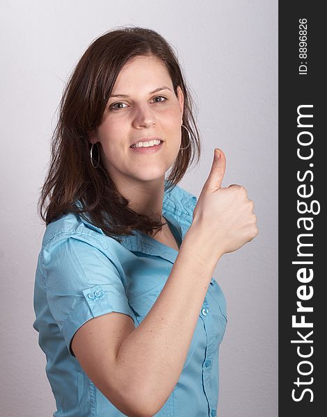 Closeup portrait of a happy young woman showing a successful gesture.