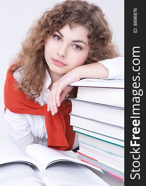 Portrait of the beautiful girl sitting at a table with textbooks