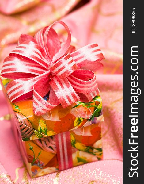 Pink gift box on silk background