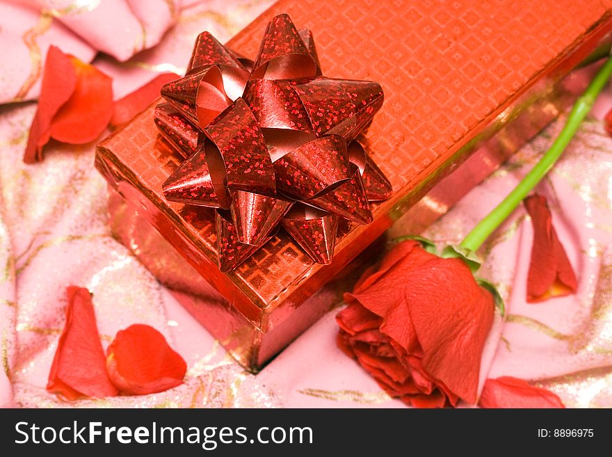 Gift box with rose on a silk surface
