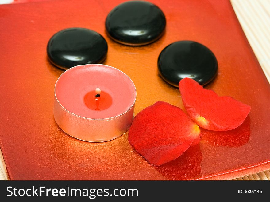 Spa essentials (candle, stones and petals of red rose)
