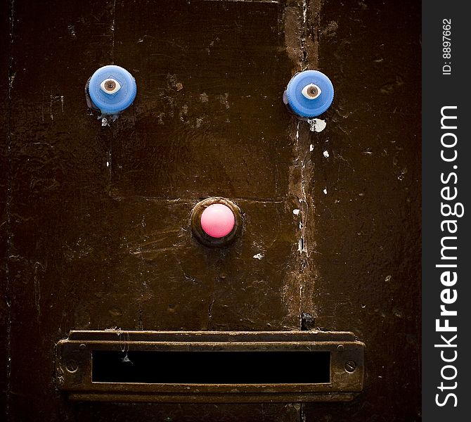 Detail of a door with pink nose and blue eyes. Detail of a door with pink nose and blue eyes