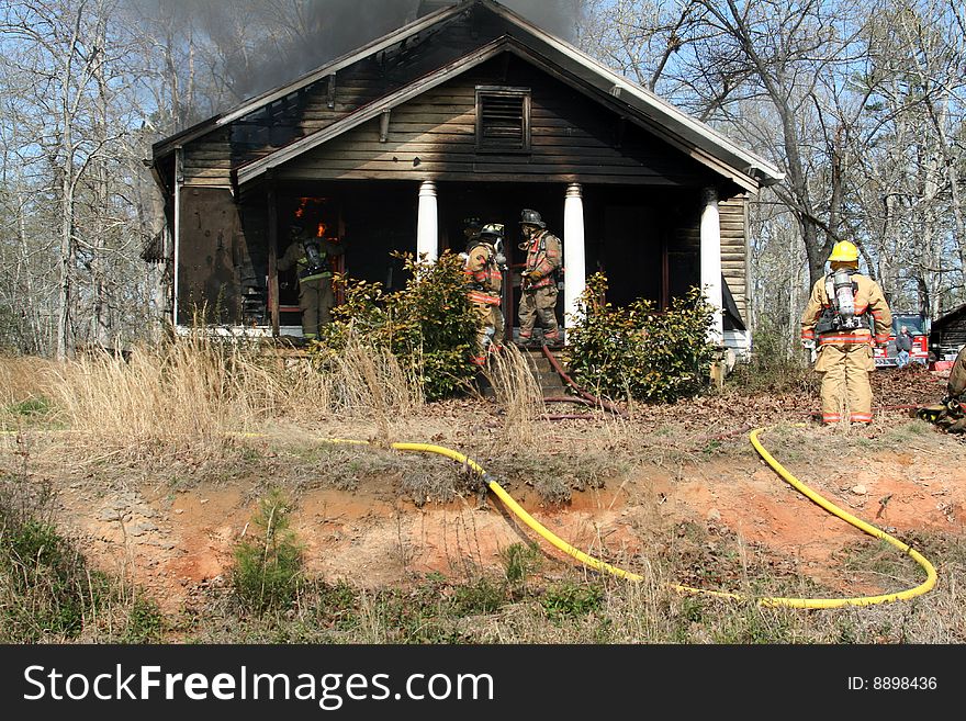 Firefighter putting out fire on house. Firefighter putting out fire on house