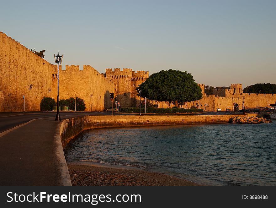The medieval wall and harbor, Rhodes, Greece, at sunrise.