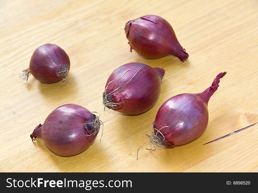 Many Ripe , Red Onions On A Wooden Background