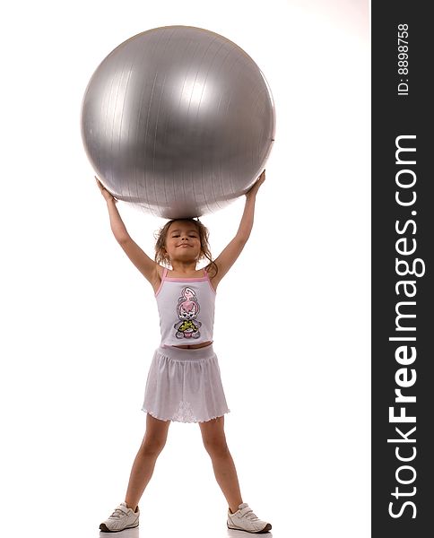 Young girl holding a big gray ball in their hands over their heads. Young girl holding a big gray ball in their hands over their heads