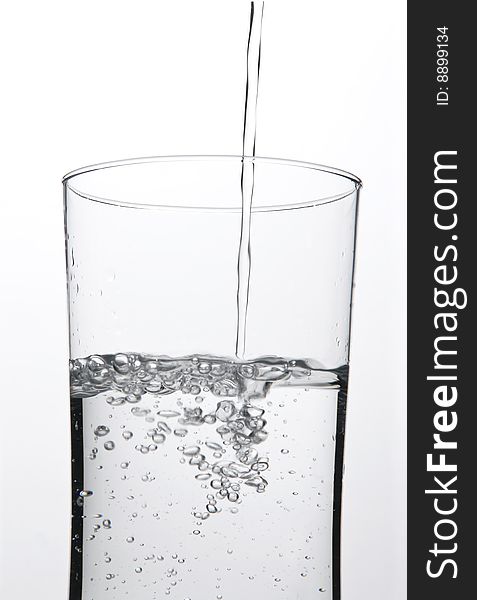 A shot of a glass of water as the water is being poured into the glass. A shot of a glass of water as the water is being poured into the glass