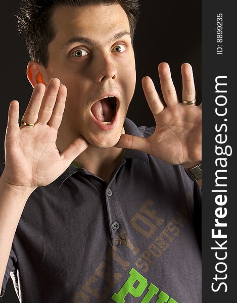 A young guy screaming with his hands near his mouth. A young guy screaming with his hands near his mouth