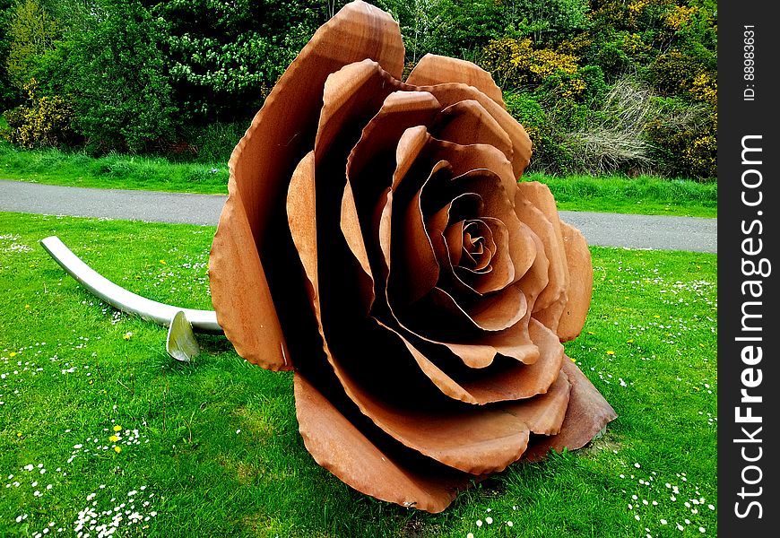 A sculpture of a rose in a park. A sculpture of a rose in a park.