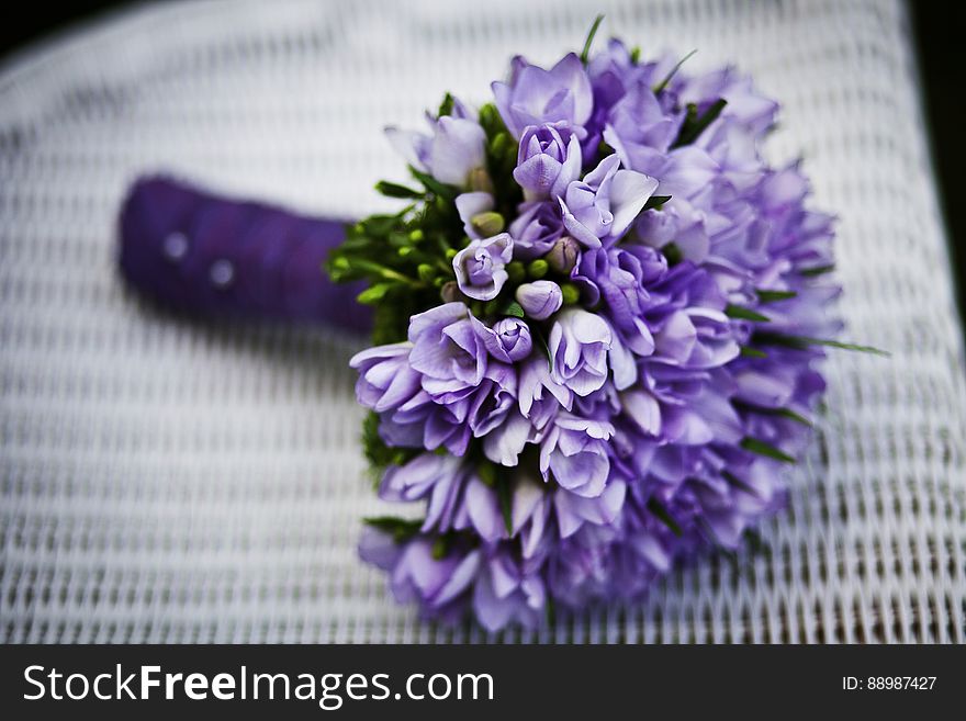 Purple Flower Bouquet on White Woven Chair